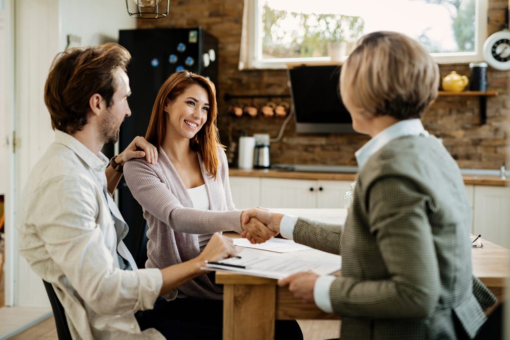 Melbourne couple shaking hands with their conveyancer after comparing cheap conveyancing quotes